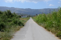 >Unebene, gerade Straße mit Blick auf das Dikeos-Gebirge